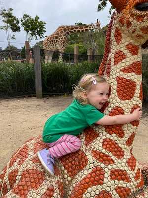 Avery riding a giraffe (statue)