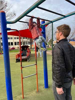 Avery swinging from the monkey bars